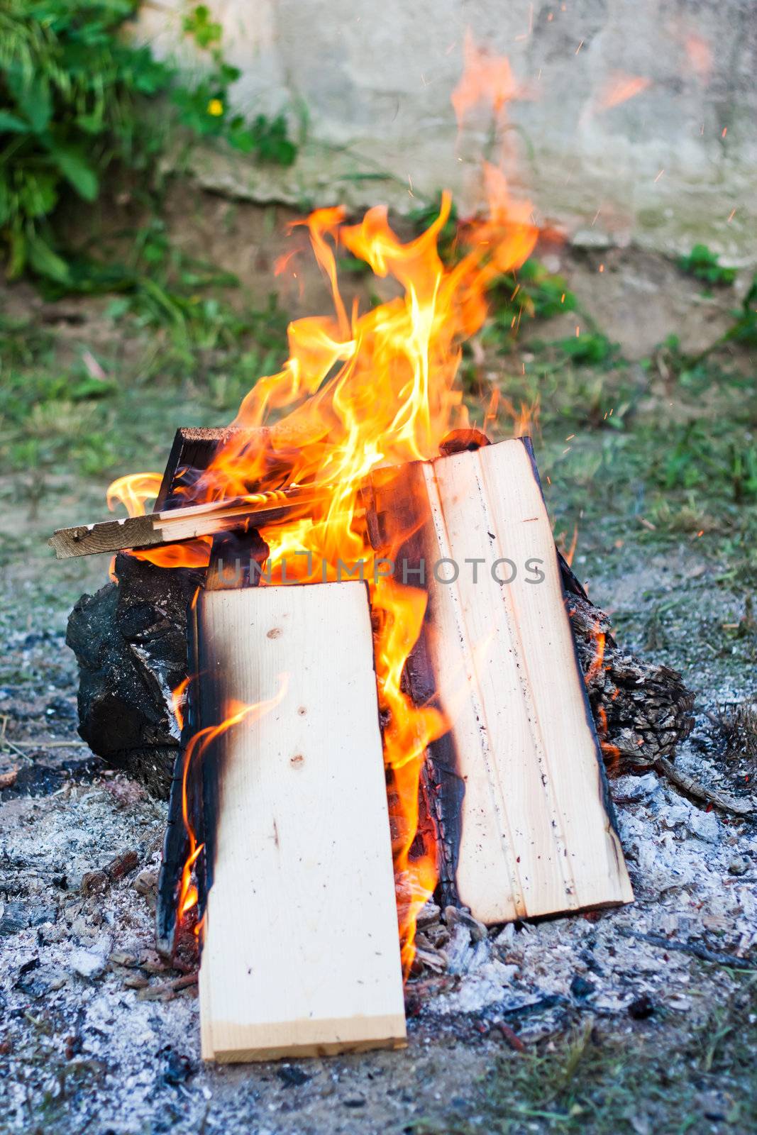 A campfire on the grasse, with boards