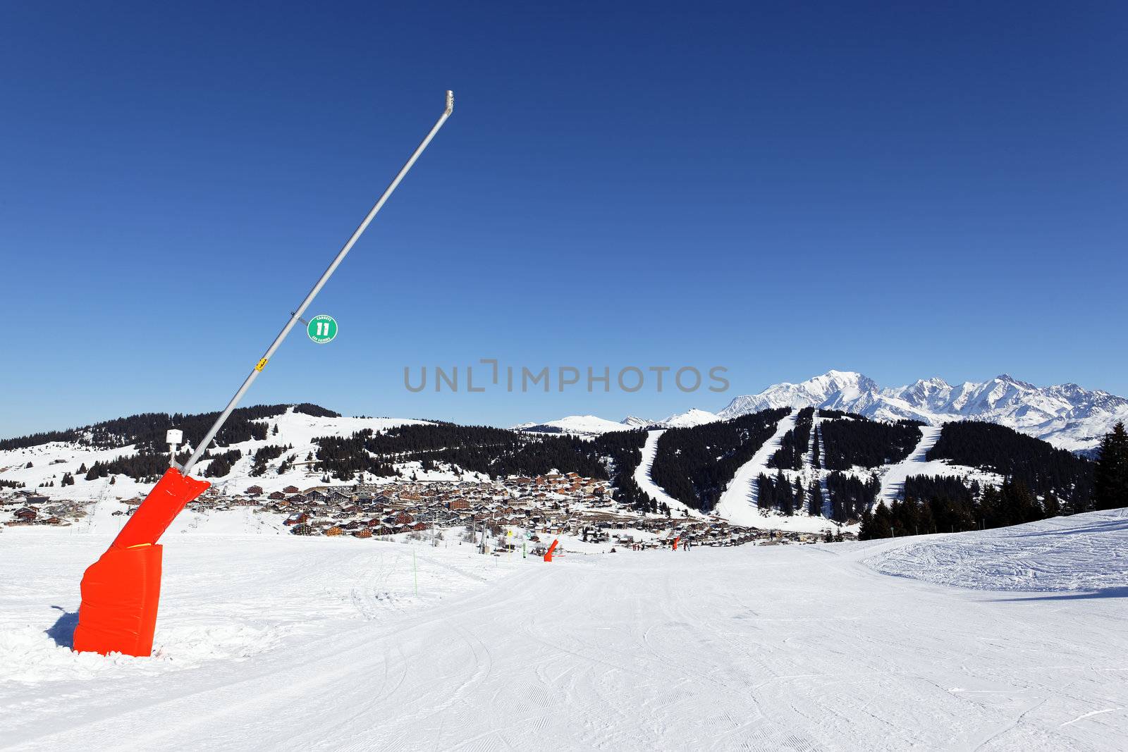 snowmaker on ski track in alpine mountain