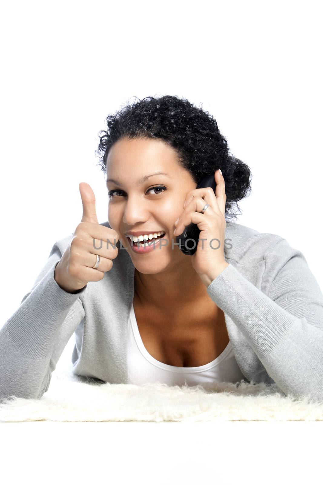 African American woman showing her thumbs up while listening through her mobile phone