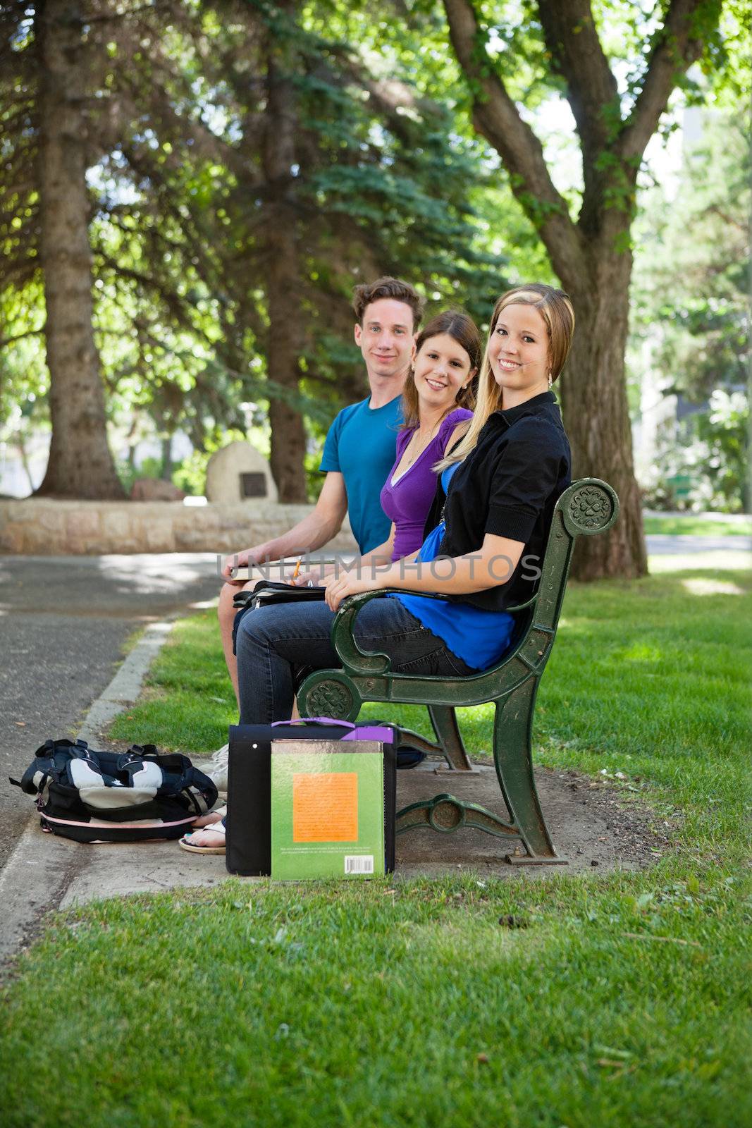 Portrait of students sitting on university campus bench