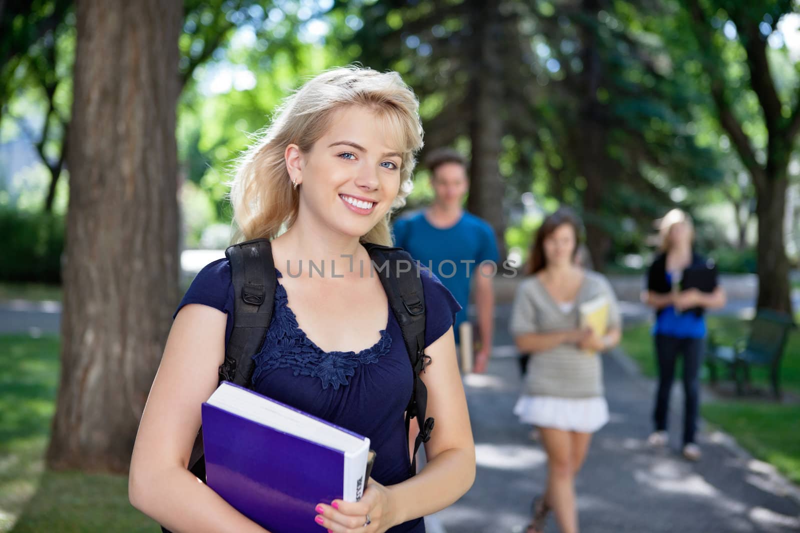 Happy young college girl by leaf