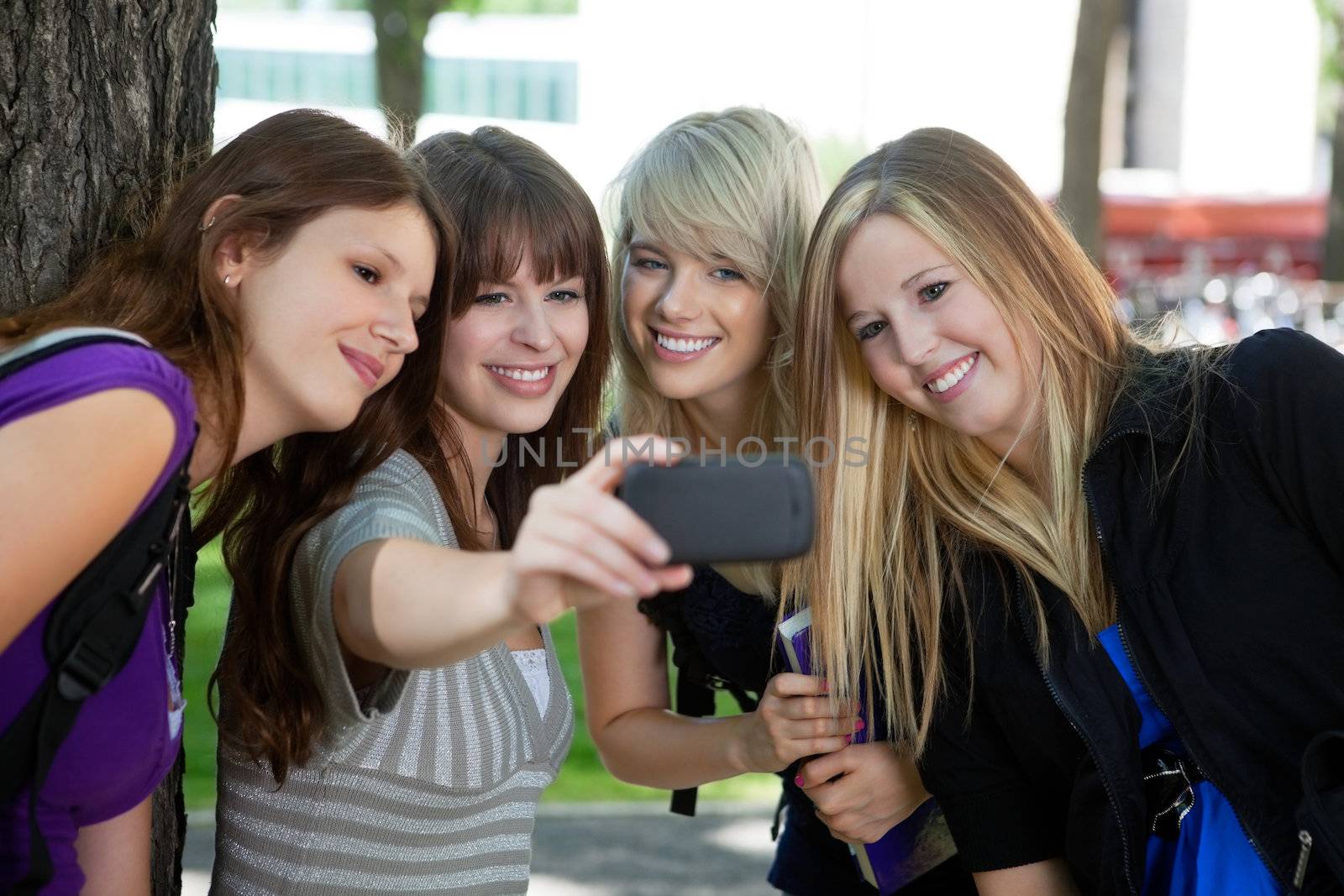 Teenage girl taking a self-portrait of her female friends