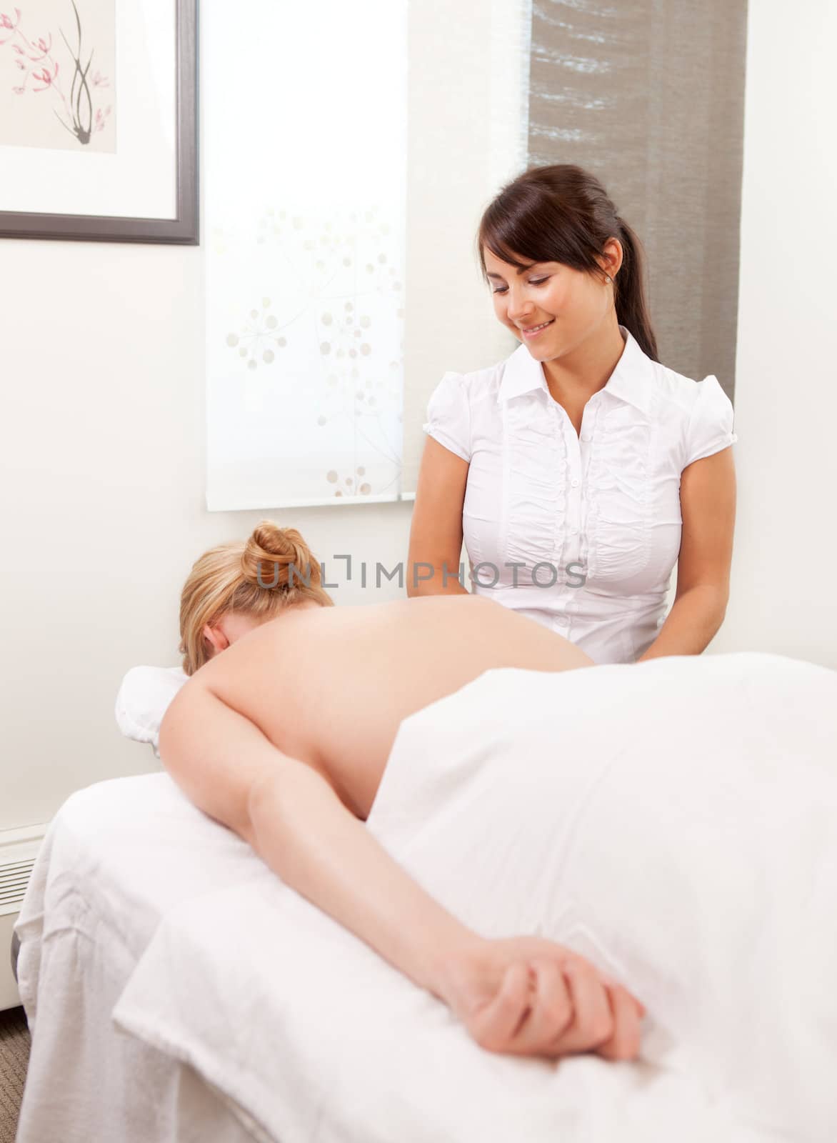 A female acupuncturist looks down on patient ready for therapy