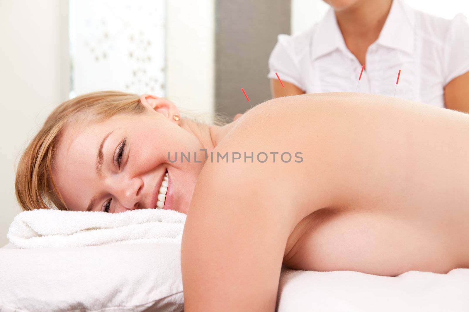 Portrait of a happy acupuncture patient with needles inserting in the Back-Shu points
