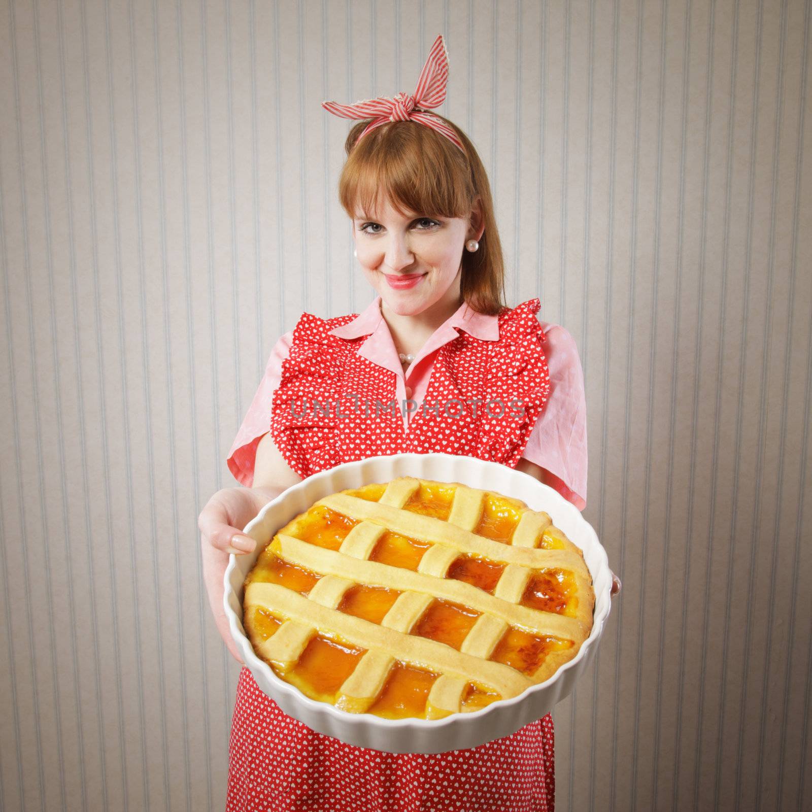 Retro housewife holding hot italian pie.