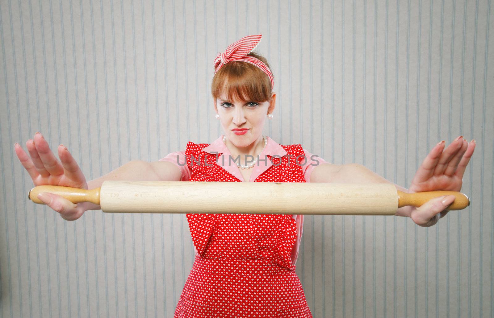 Retro housewife holding a rolling pin, ready to fight