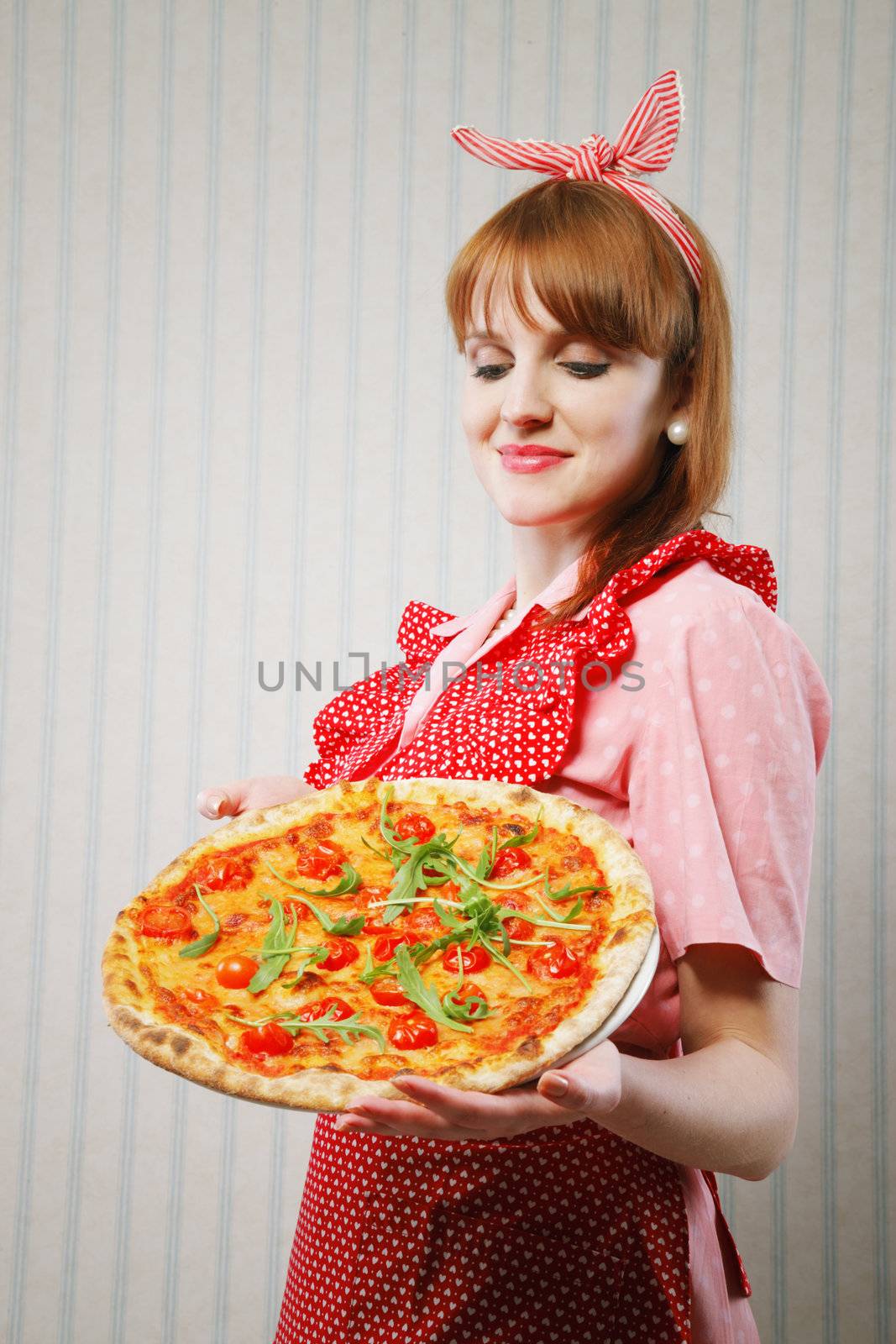 Young housewife holding a vegetarian pizza for lunch