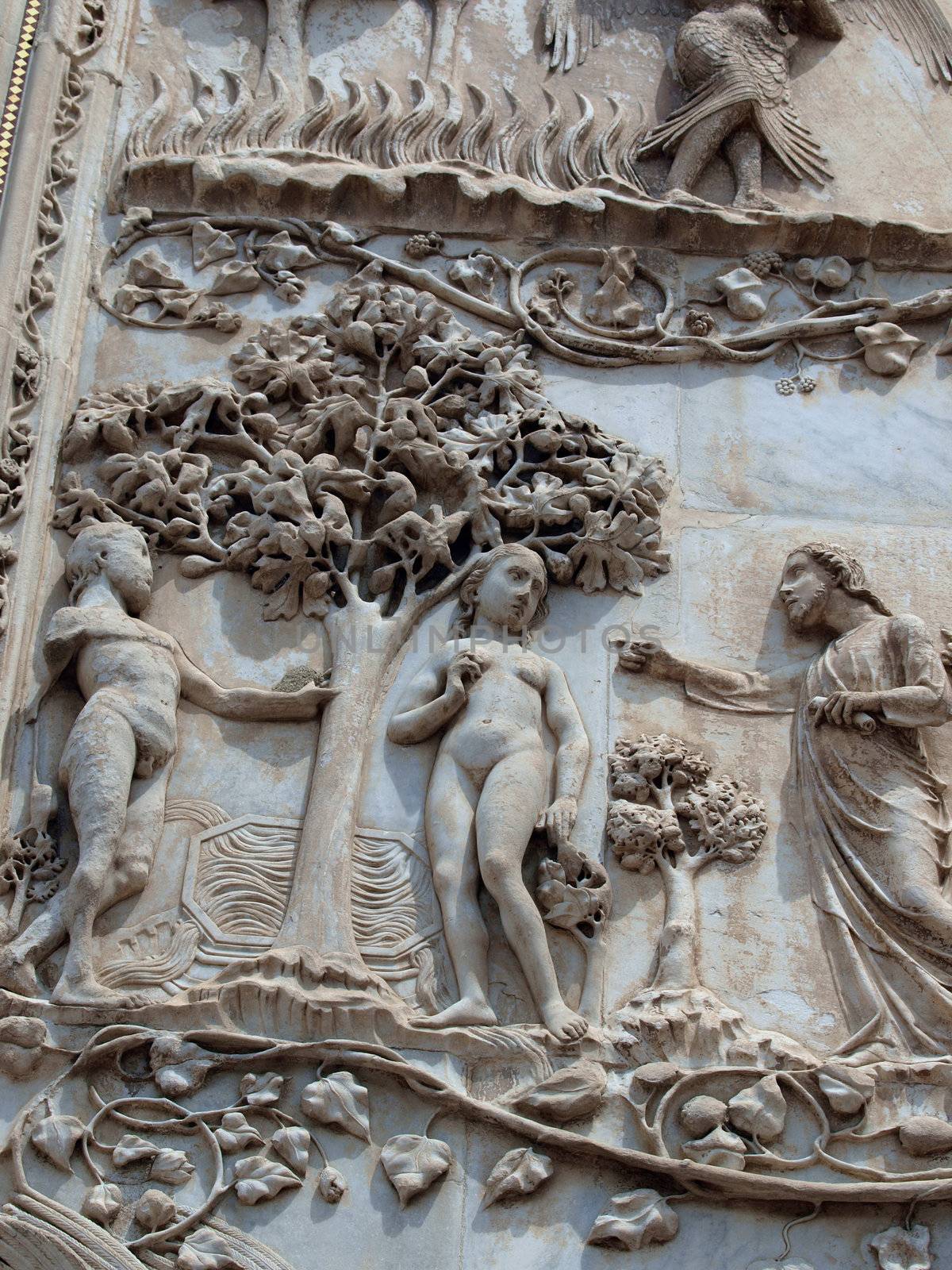 Orvieto - Duomo facade. The first pillar: scenes from Genesis. In the company of angels, God forbids Adam and Eve eat the fruit from the tree