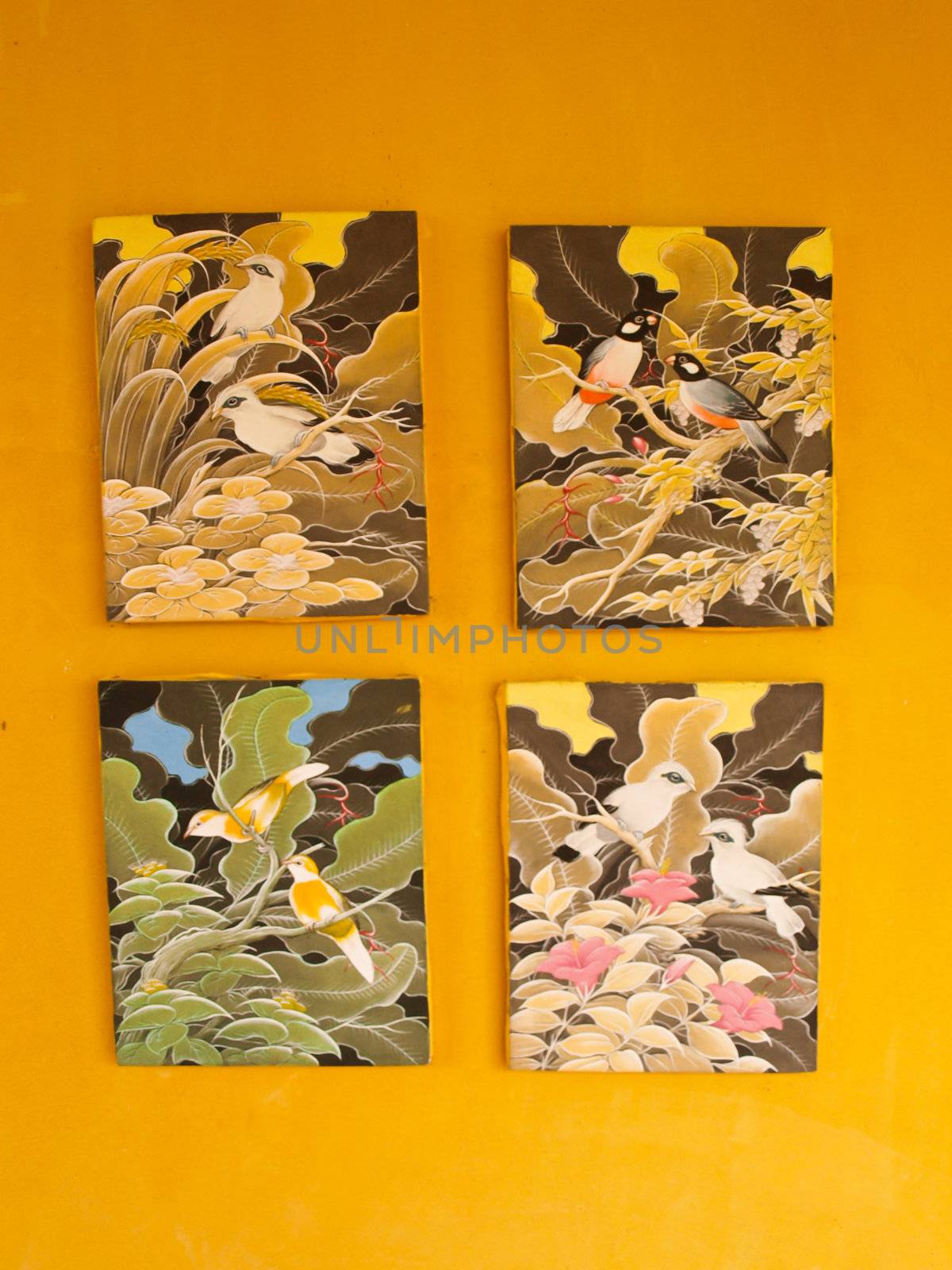 Four bird painting frames on yellow wall