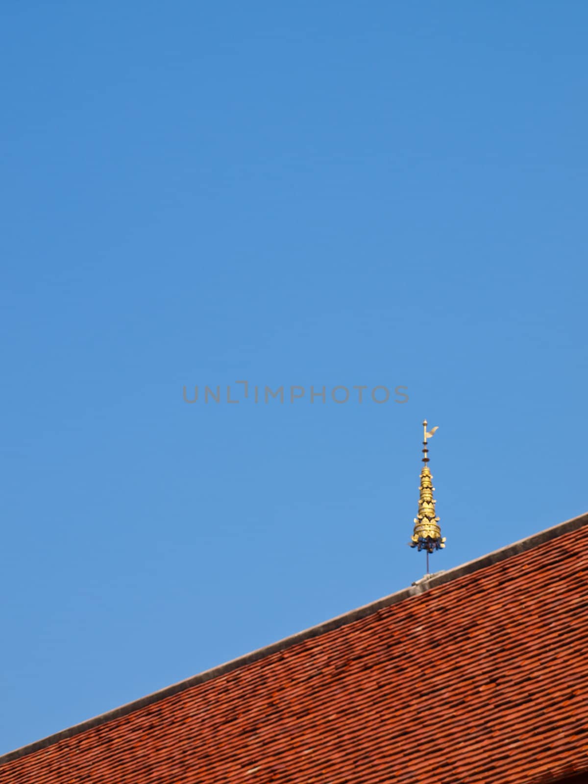 Traditional clay roof tiles in the North of Thailand on blue sky by gururugu