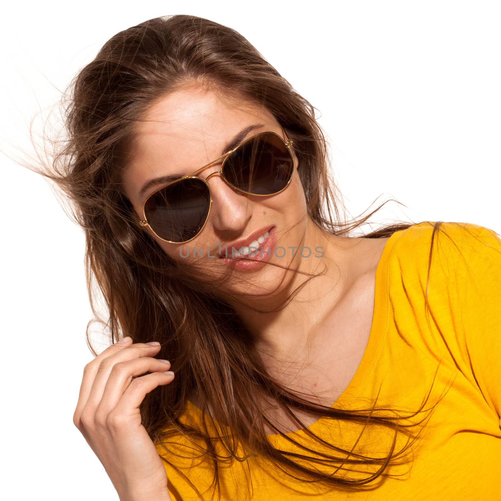 Positive young woman in yellow shirt with sunglasses over white background