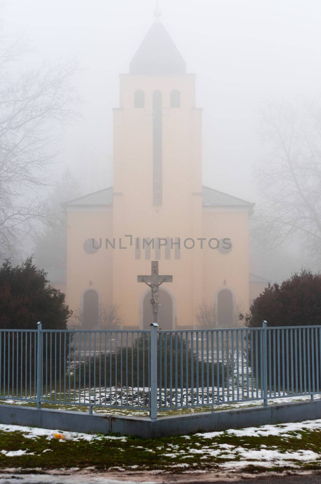 Church in the fog with stone cross and fence by svedoliver