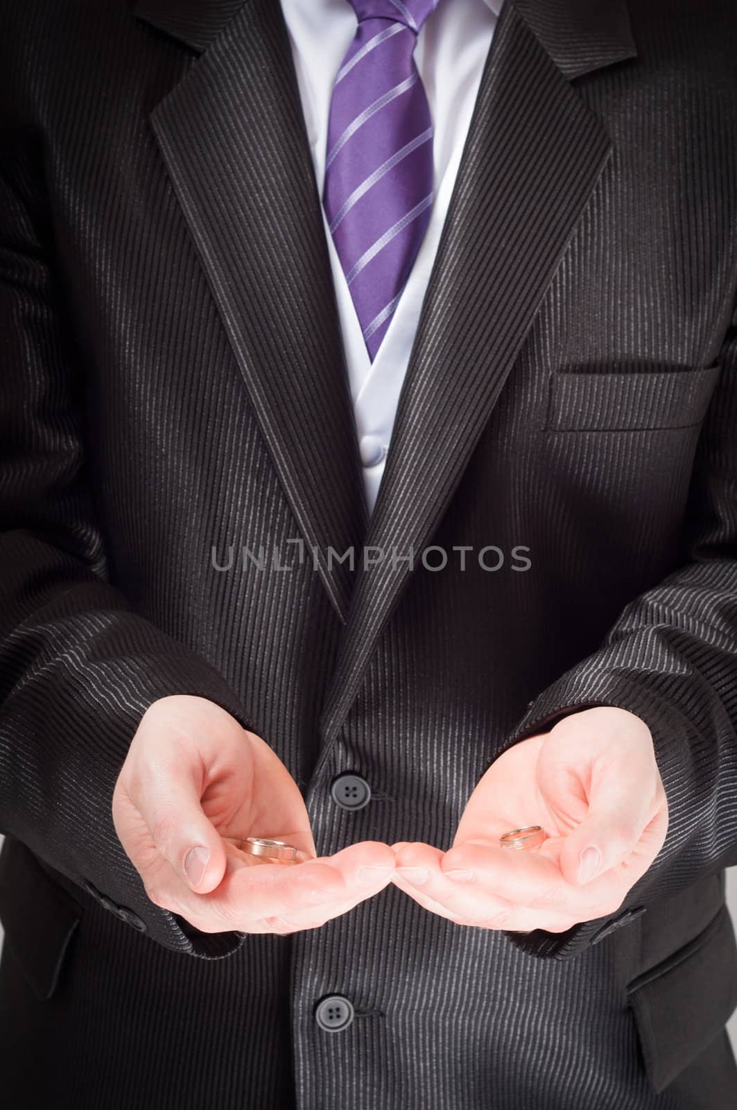Groom holding the ring of marriage in his hands