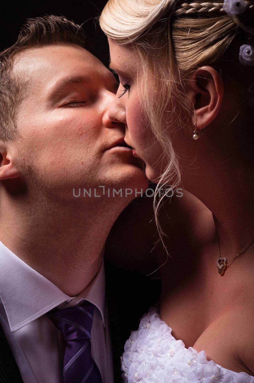 young couple in wedding wear kissing by svedoliver