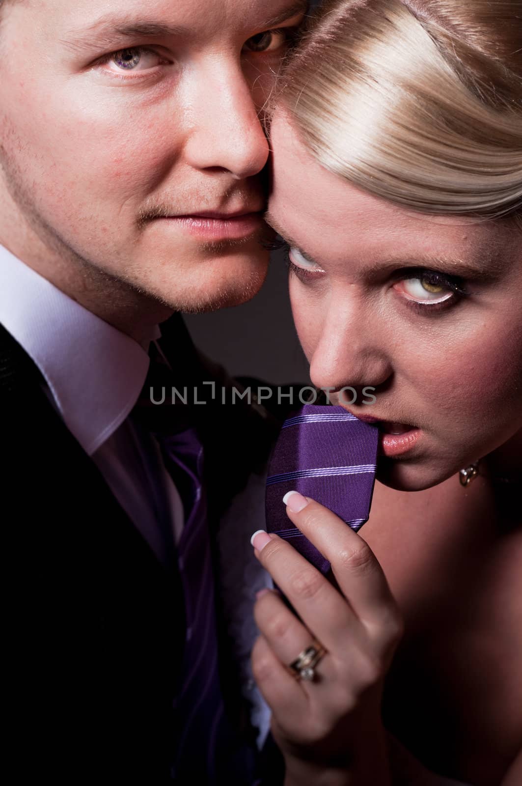 Beautiful young bride holding her groom on a leash