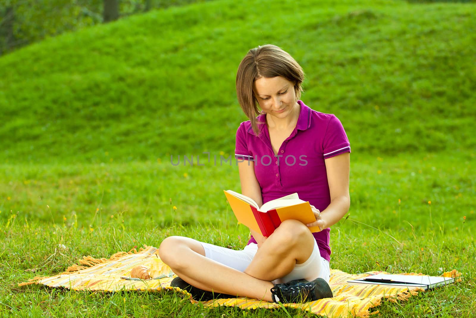 Beautiful woman enjoying a funny book, horizontal