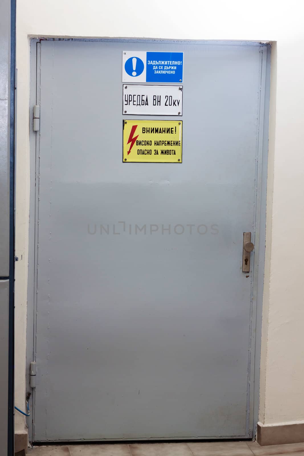 Industrial door with high voltage warning sign