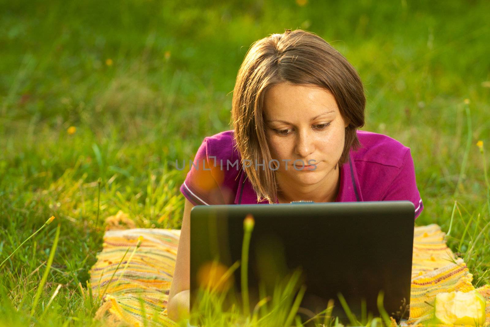 Beautiful woman with a laptop in the park by Lamarinx