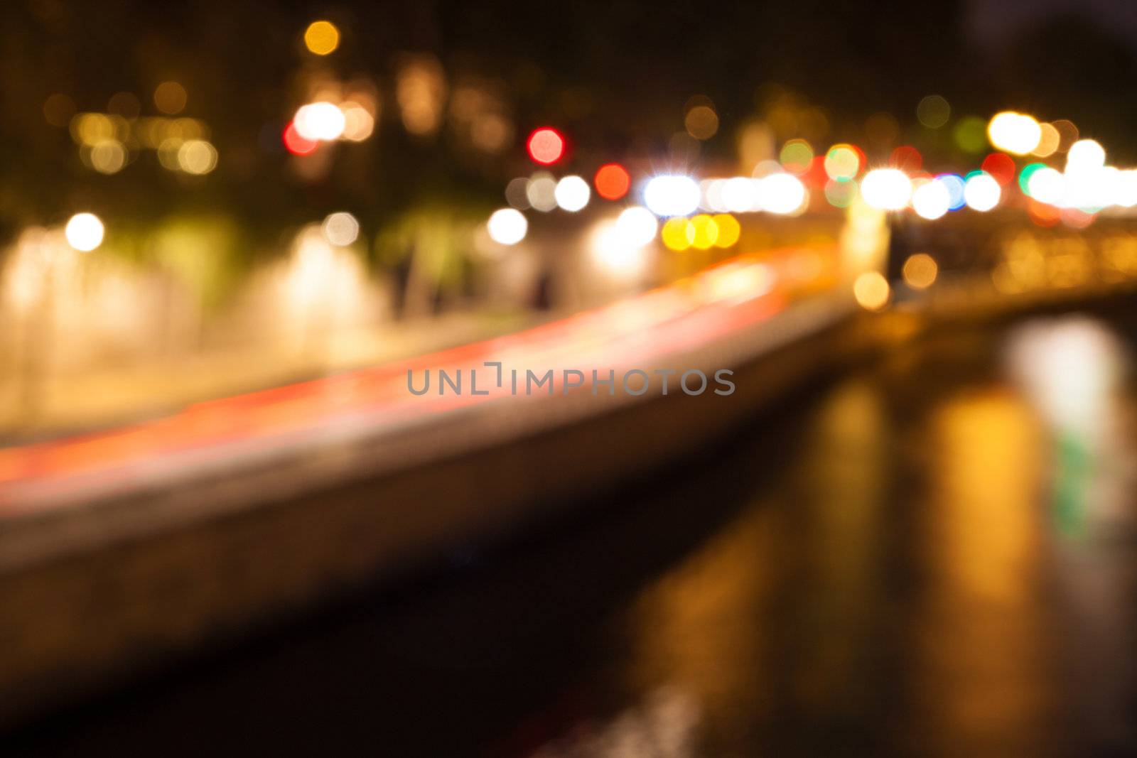 Bokeh of city lights with reflections in a river by Lamarinx