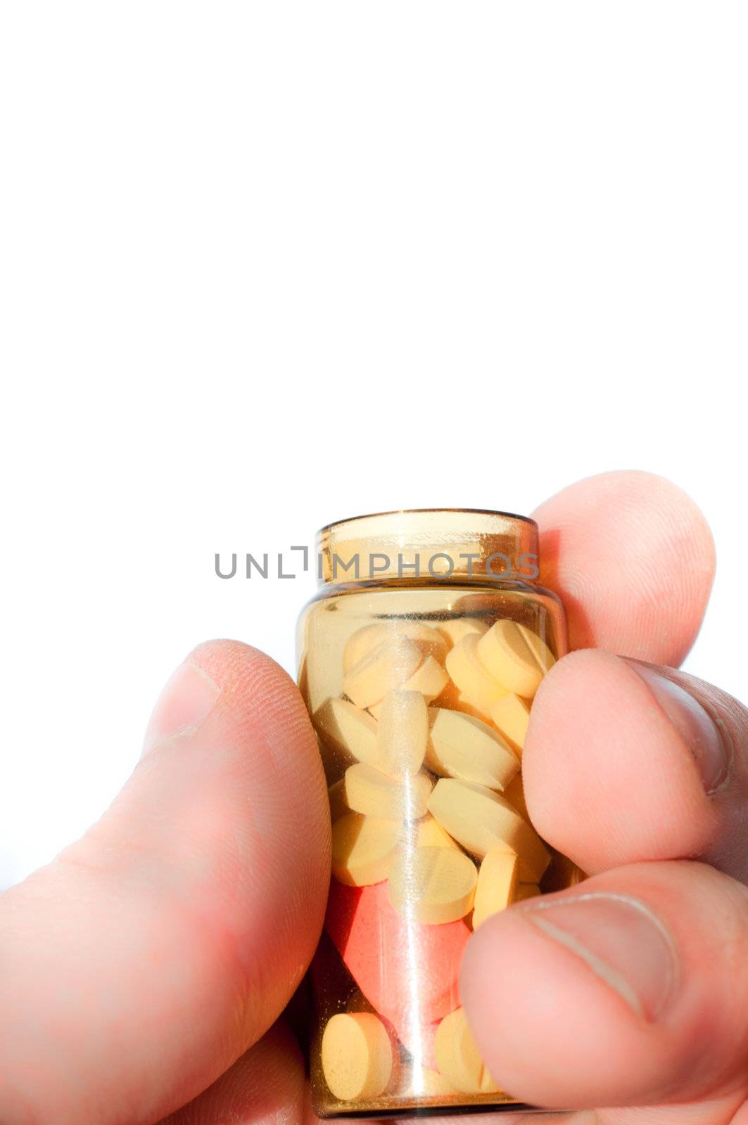 Hand holding medicine bottle full of pills