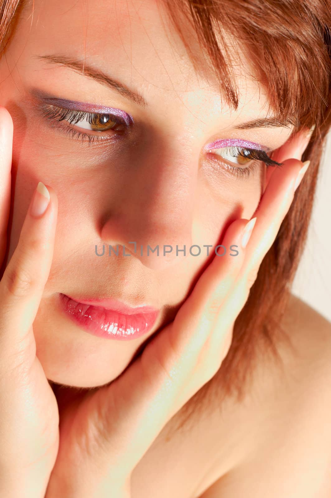 Closeup of a young woman holding her face with hands