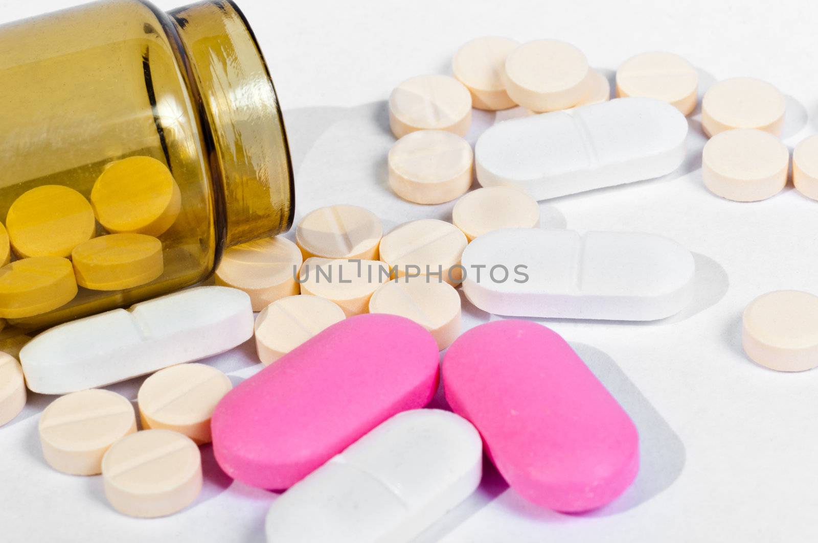 Medicine bottle with pills on white isolated background