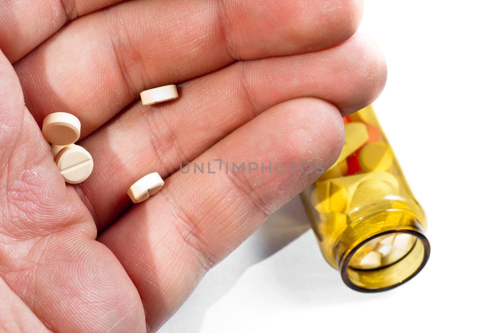 Hand of a man holding pills with medicine on background