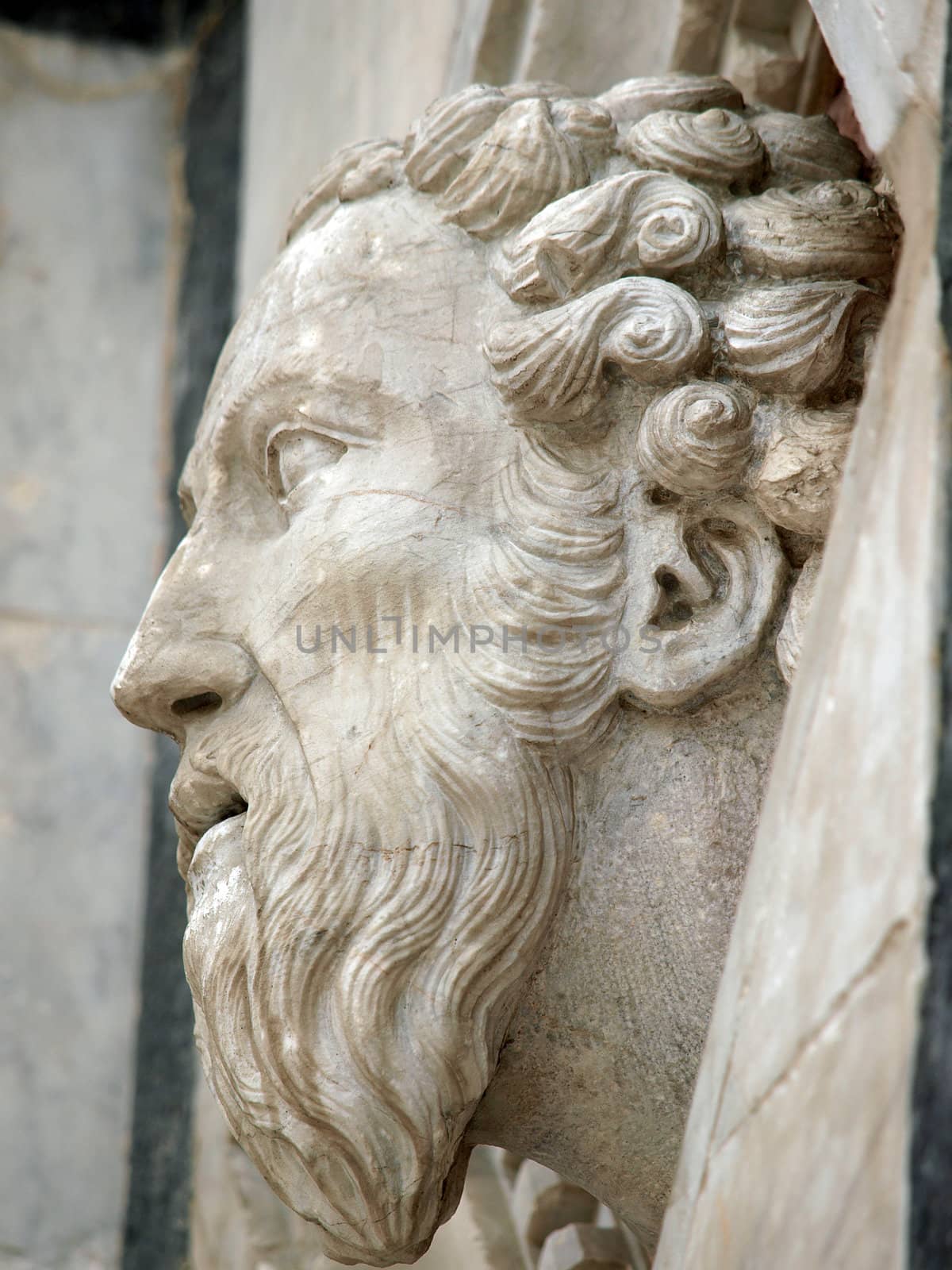 Siena - Head carved in marble on the facade of the Baptistery