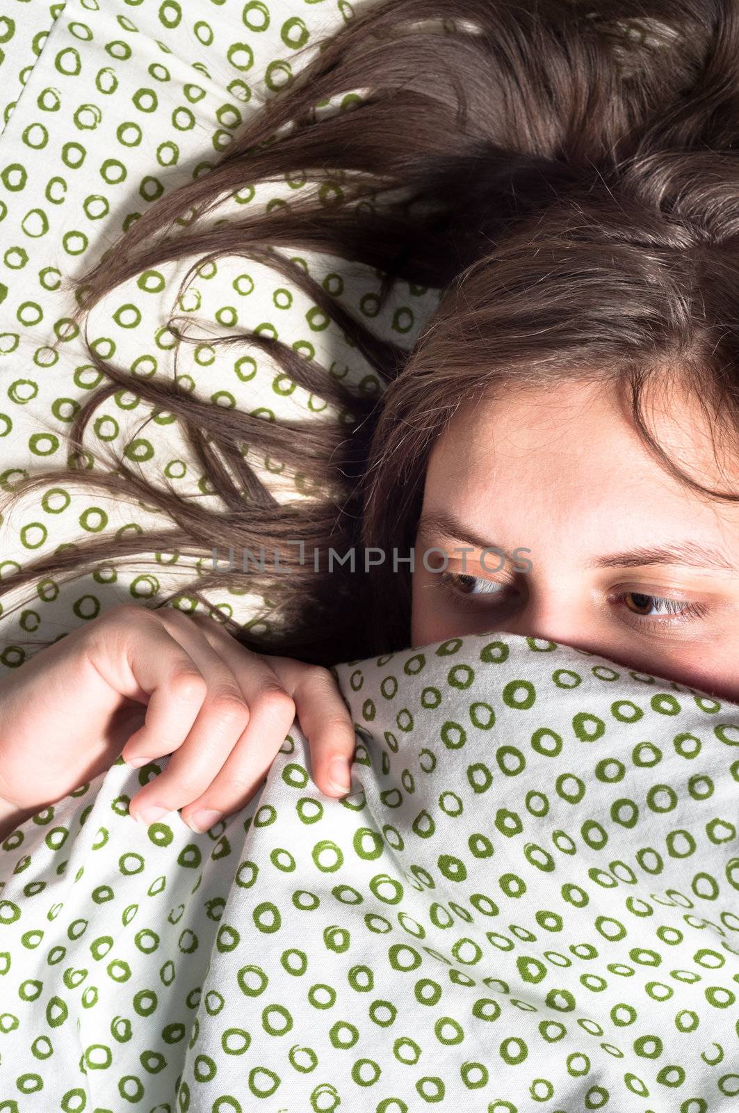 Girl scared of something under blanket