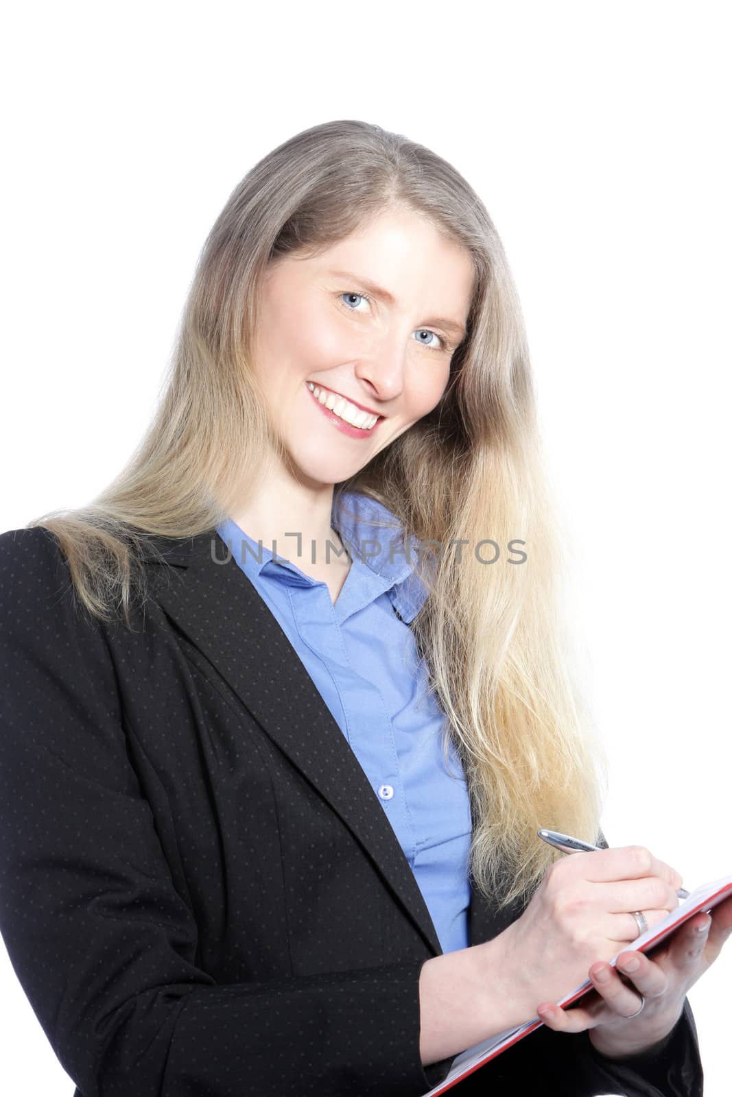 Smiling businesswoman with long blonde hair standing writing notes on a handheld clipboard