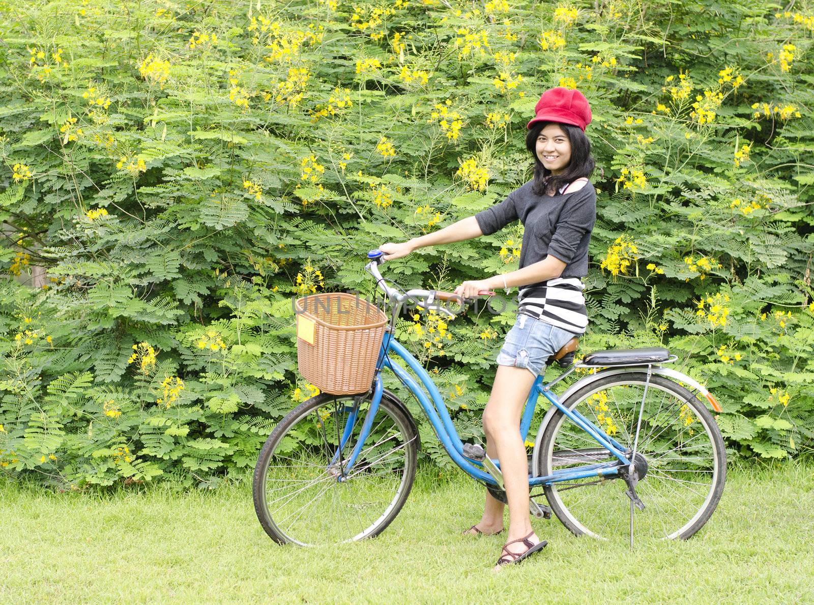 Portrait of an happy smiling girl riding a bicycle in the park