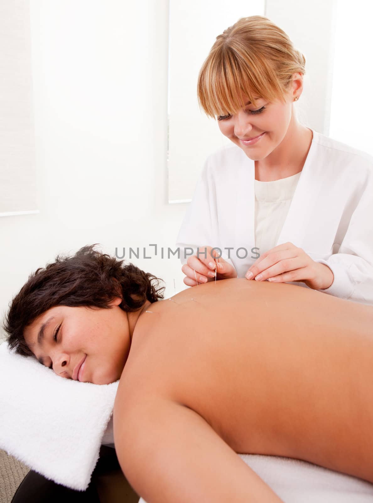 Acupuncturist with Young Male Patient by leaf