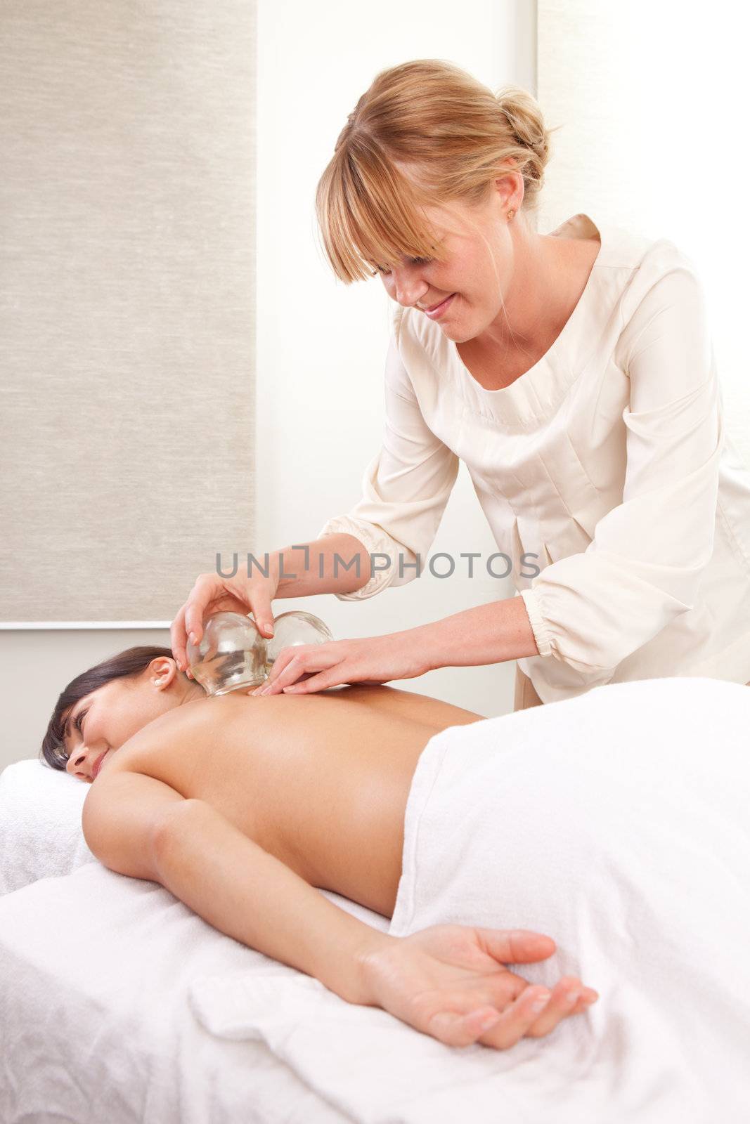 Portrait of an acupuncturist removing a glass globe in a fire cupping therapy session