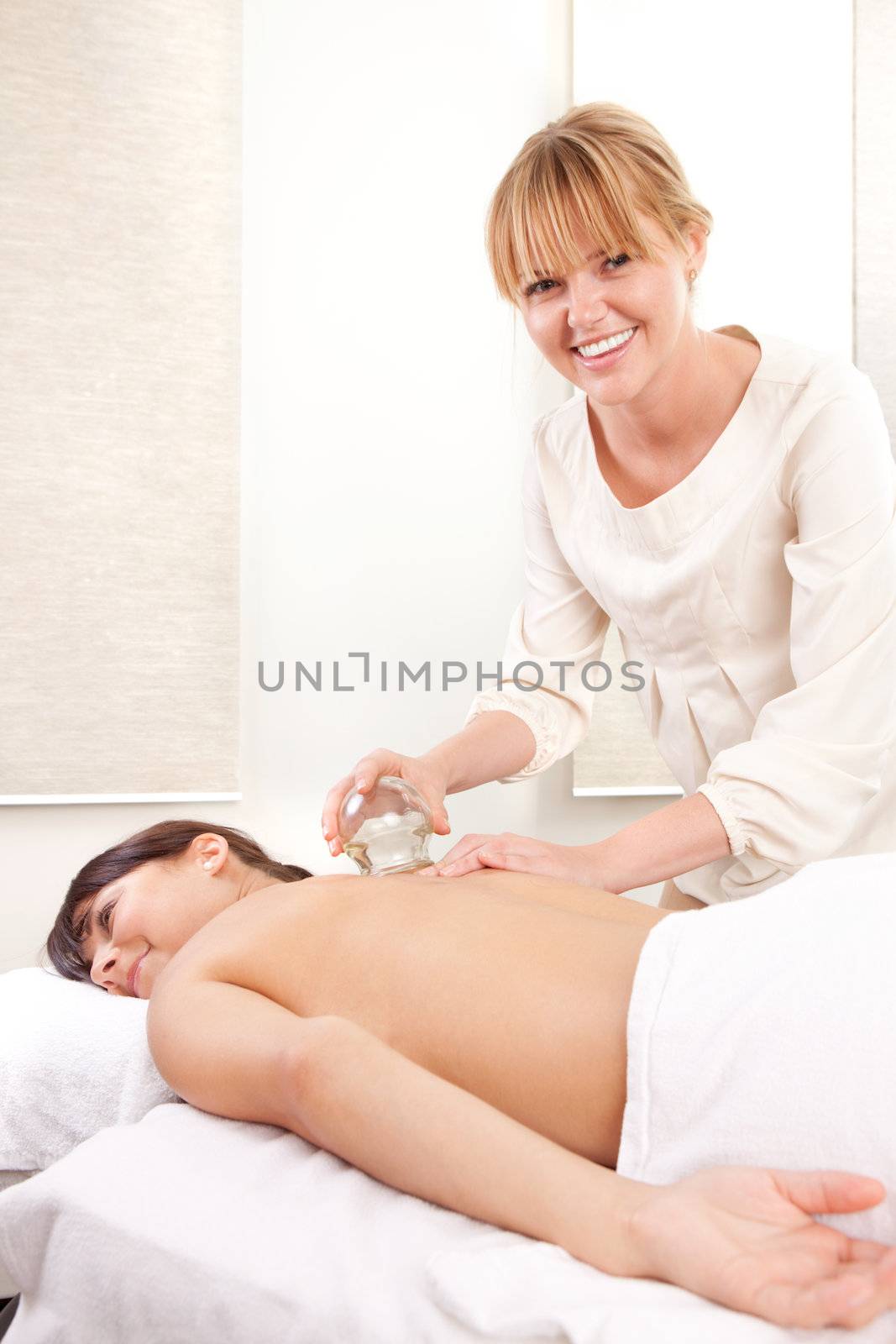 Portrait of an acupuncturist removing a glass globe in a fire cupping therapy session