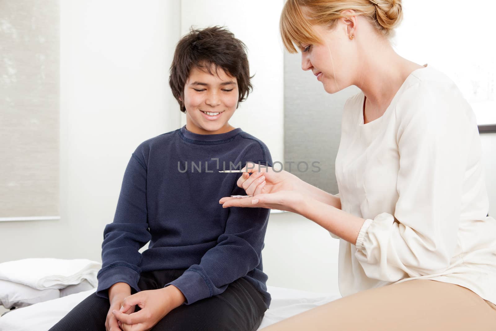 Professional acupuncturist showing needles to young patient