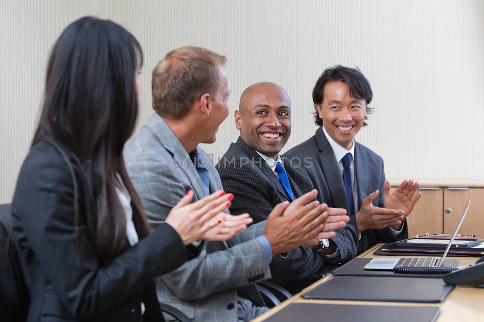 Professionals applauding during a business meeting by leaf