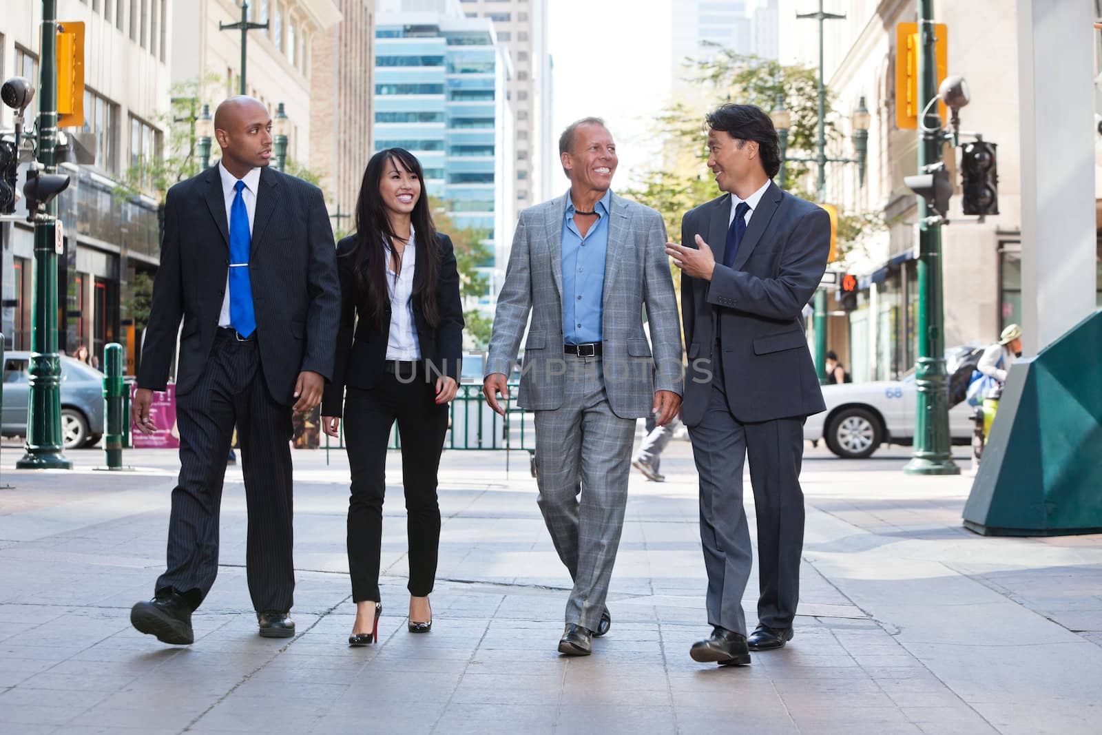 Business people walking together on street by leaf