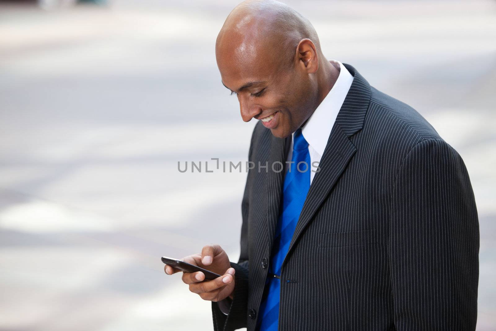 African American Business Man Texting by leaf