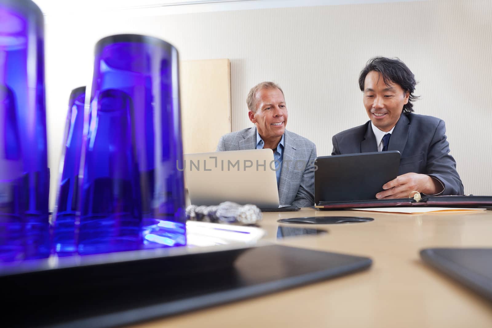 Two handsome businessmen working together on a laptop and digital tablet