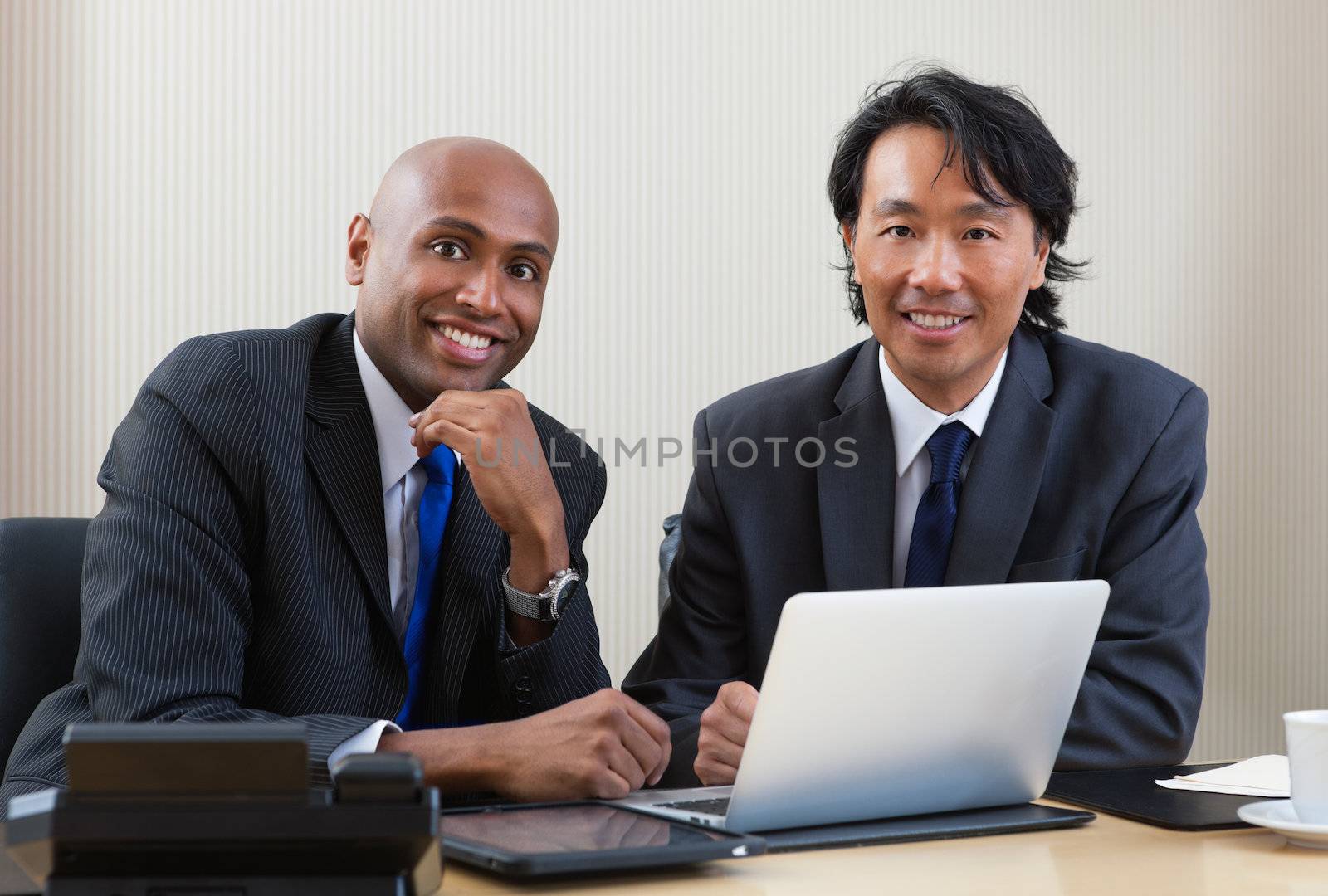 Portrait of multi ethnic business people working on laptop and digital tablet