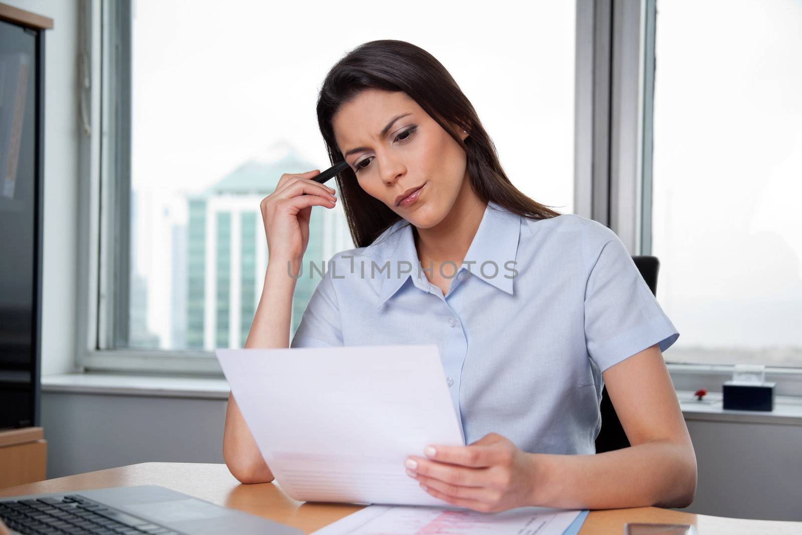 Thoughtful businesswoman reading important business papers