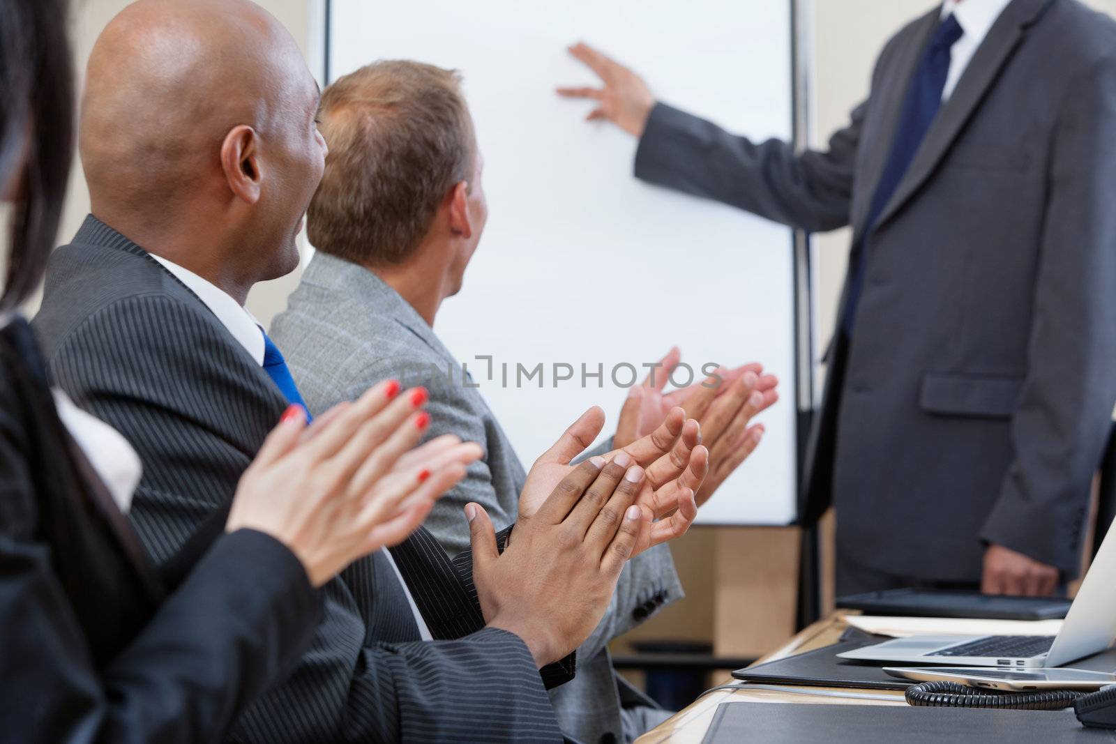 Business people applauding after speech of a businessman at the conference