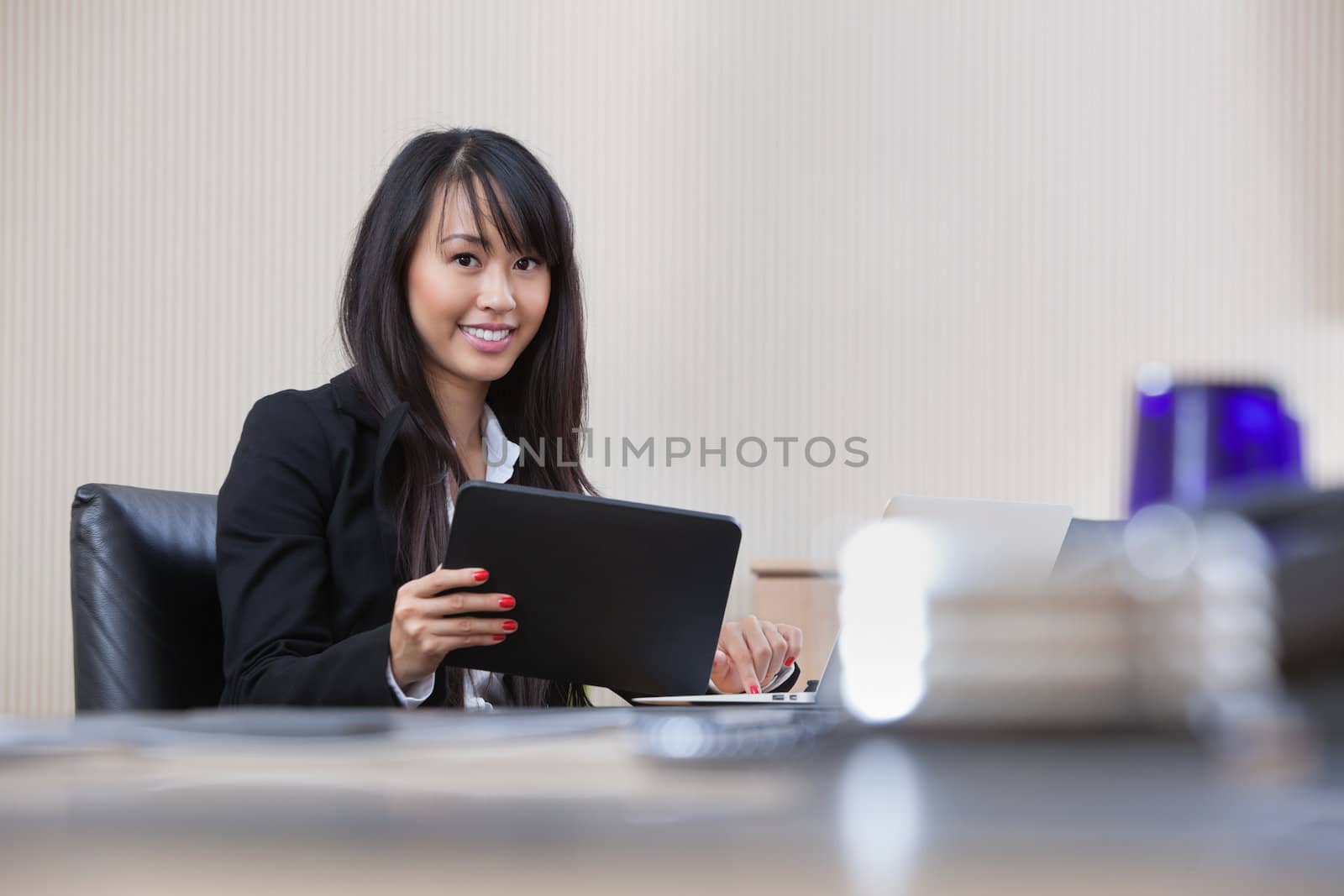 Businesswoman working on digital tablet by leaf