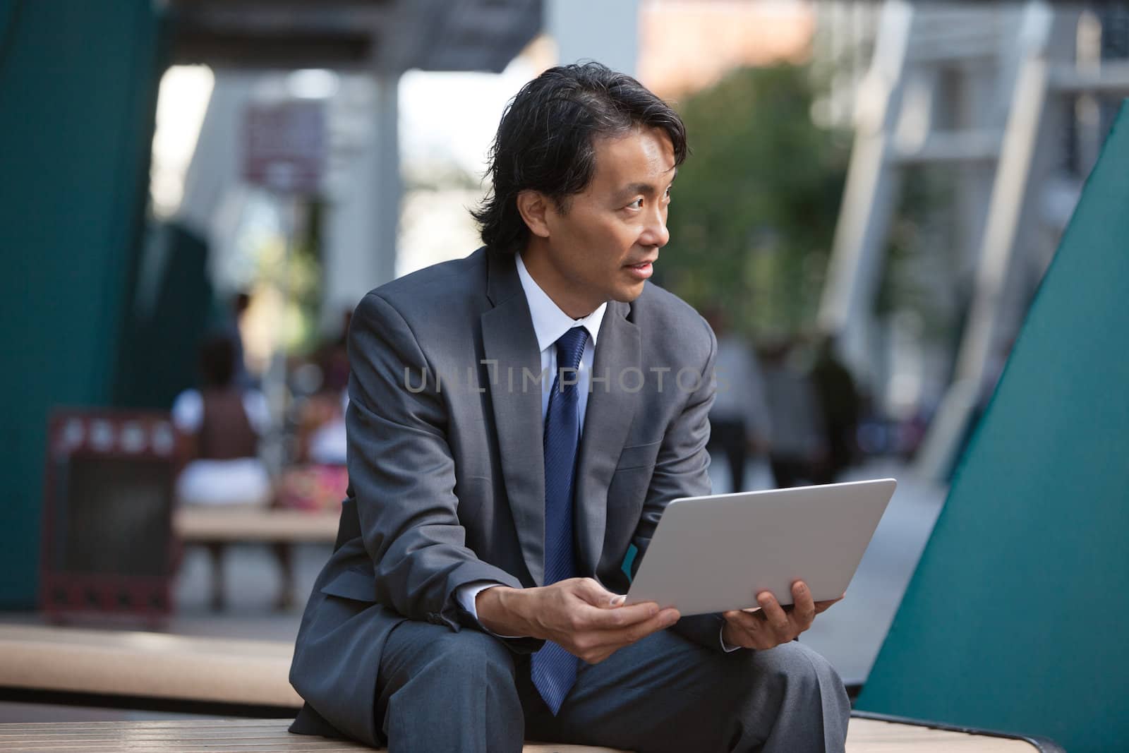 Businessman holding laptop and looking away