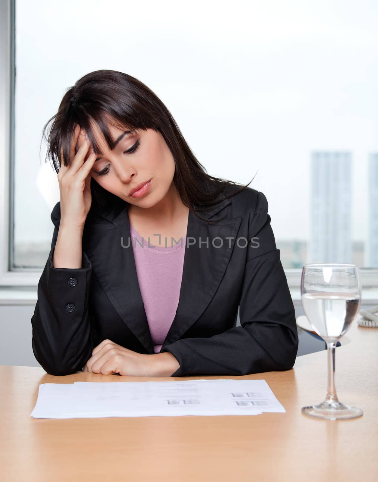 Beautiful business woman with hand on head at workplace