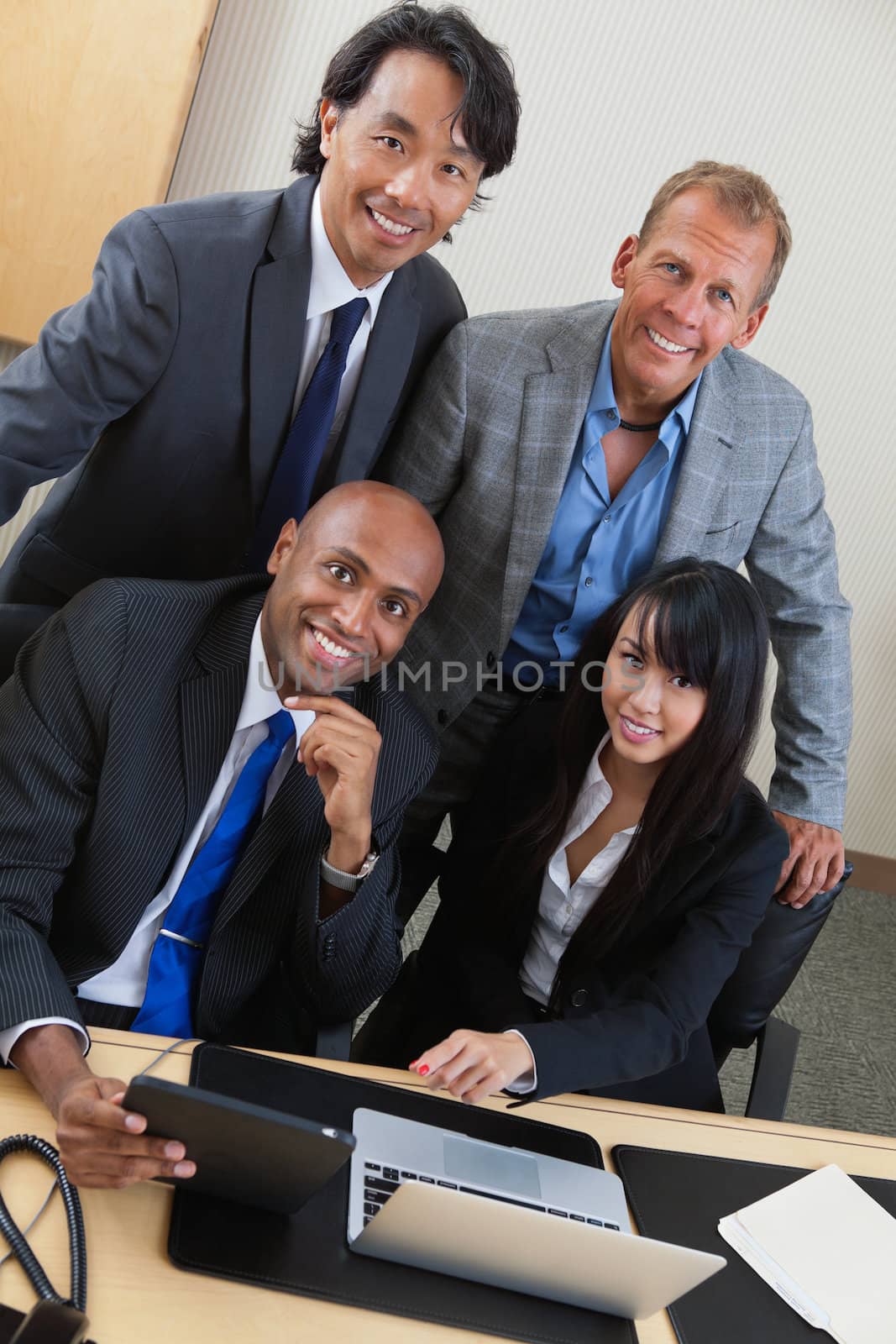 Business people working on laptop together by leaf