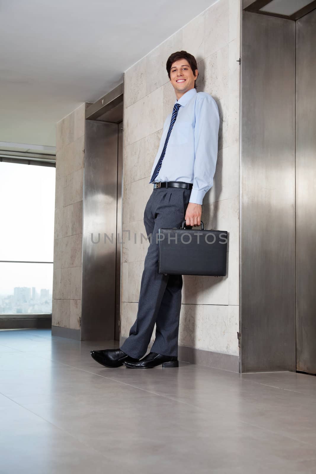 Full length of handsome male entrepreneur standing near the lift