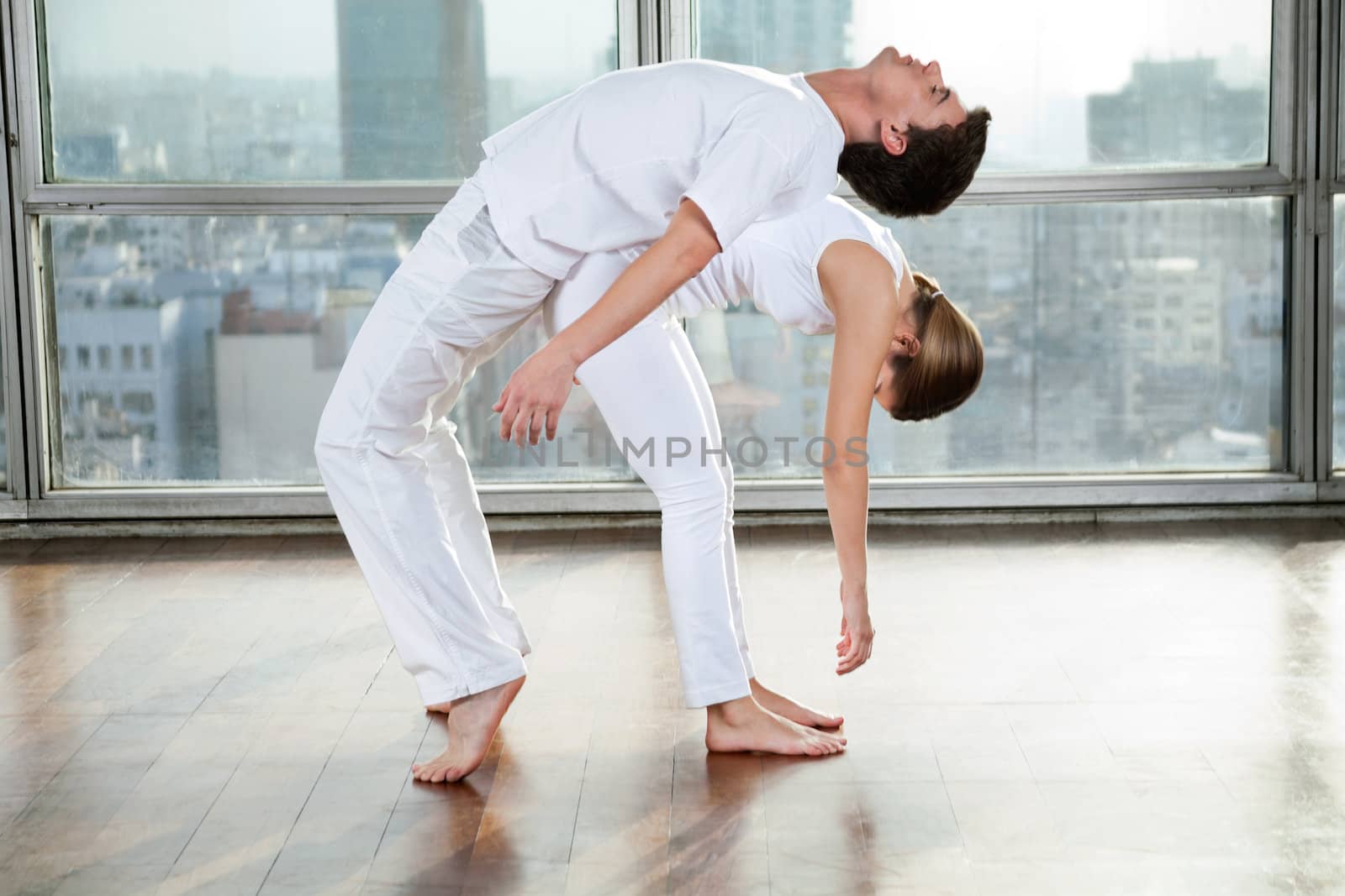 Young man and woman doing stretching fitness exercise at gym