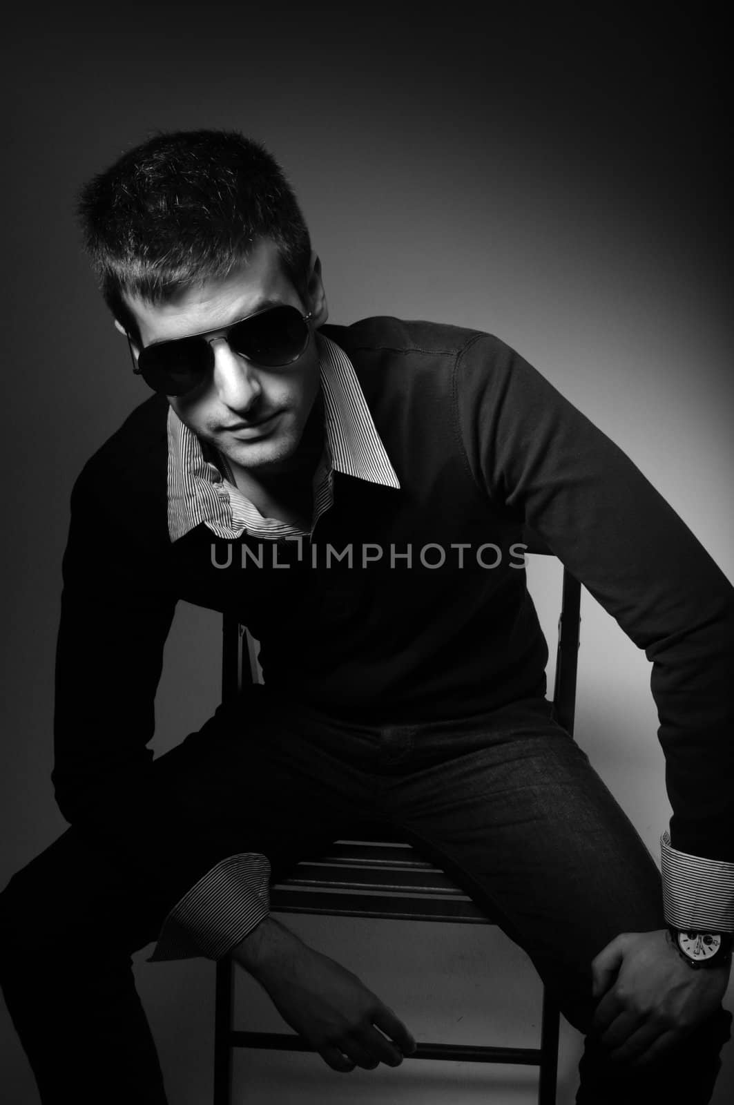 Young man sitting in chair  in sunglasses in shirt in black and  by svedoliver