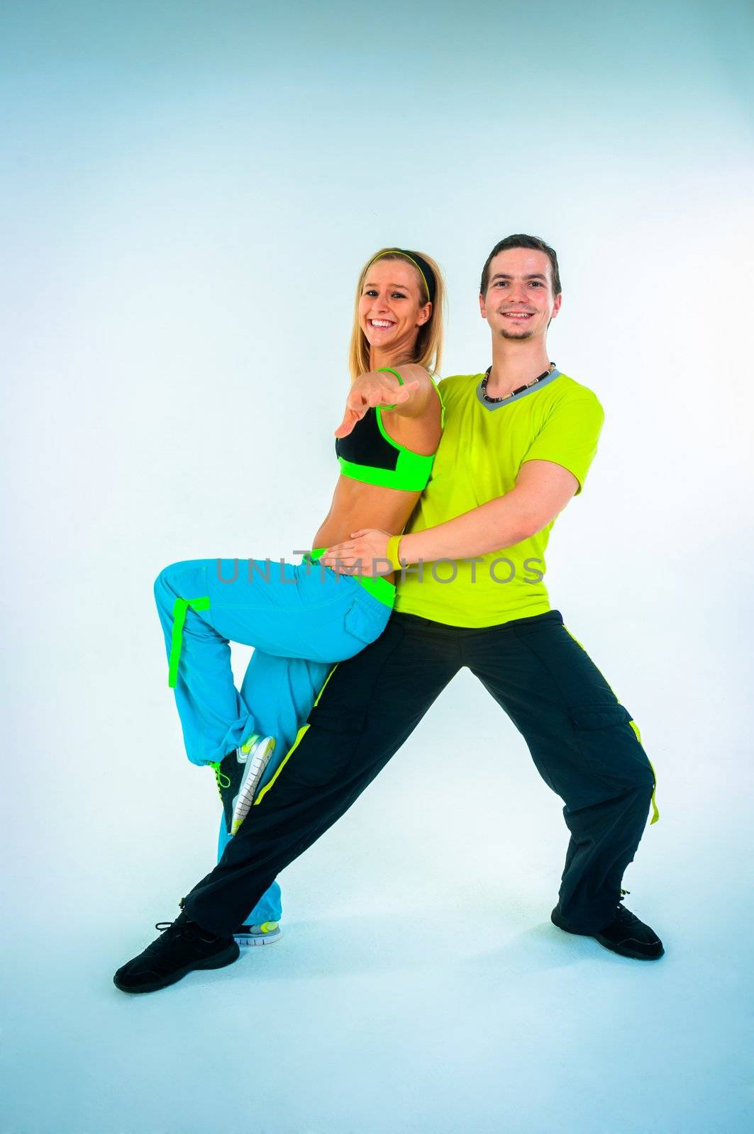 Acrobatic dancing with two young trainers on white background